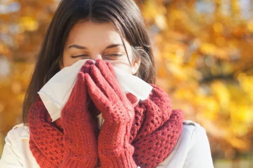 Woman with tissue having flu or allergy